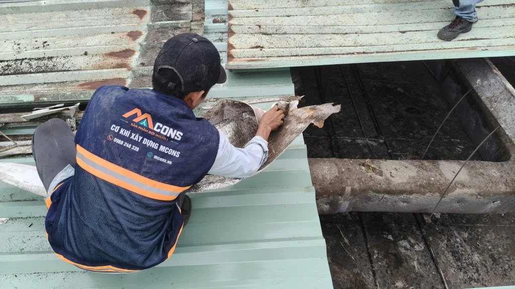 công nhân MCONS đang vệ sinh bụi bận vị trí chồng mí tôn trước khi lợp tôn mới lên.