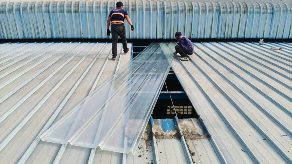 Thợ MCONS đưa tấm composite lấy sáng mới vào vị trí trên mái nhà xưởng