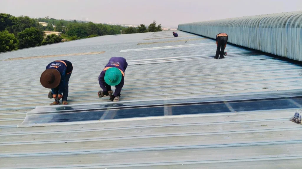 Hai thợ MCONS bắt vít hoàn thiện dải tôn lấy sáng composite mới
